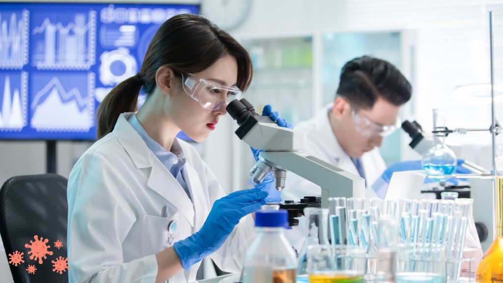 People looking through microscopes in the lab.